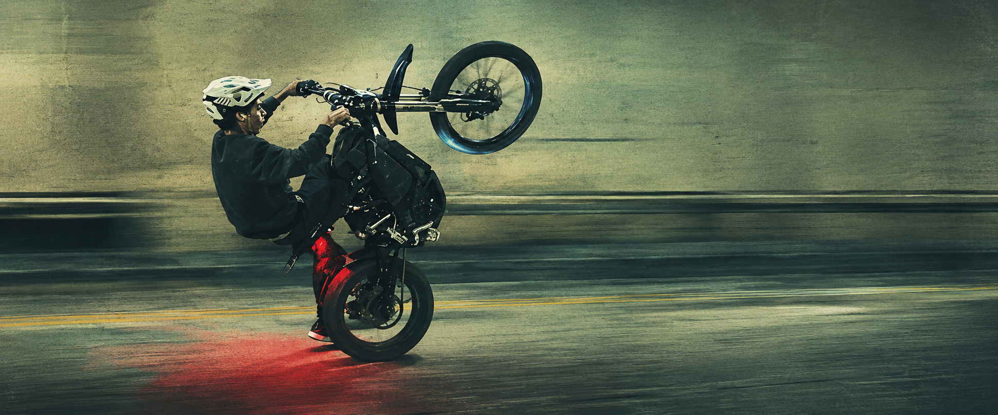 Rider pulling a wheelie on an electric moto